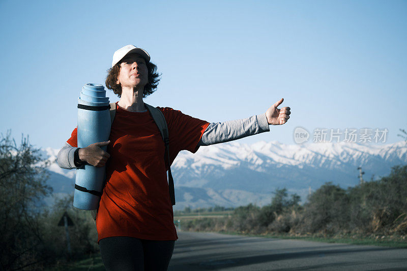 女背包客在山路上搭车