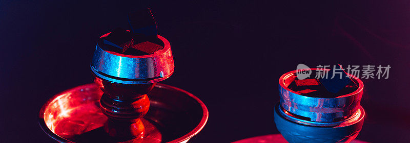 水烟碗，水烟和煤炭特写在黑色背景与彩色照明。横宽照片字幕，封面。copy-space