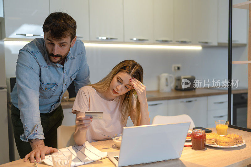 一对夫妇在家用笔记本电脑在网上预订房间