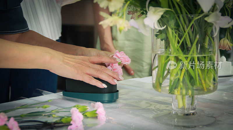 一位美丽的亚洲花艺老师正在为花艺学生示范插花技巧。