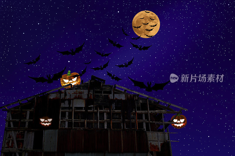 草莓超级月亮升起在一个旧仓库屋顶的万圣节南瓜上，上面有飞行的蝙蝠