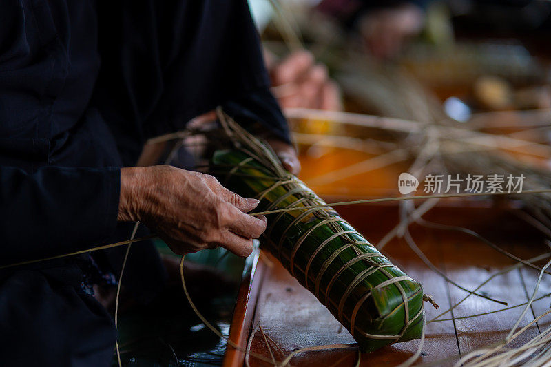 老妇匠人制作年糕特写。传统的越南新年食物。