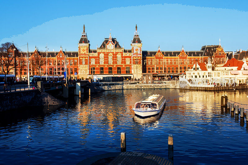阿姆斯特丹的主要火车站，游船载着游客在运河中穿梭