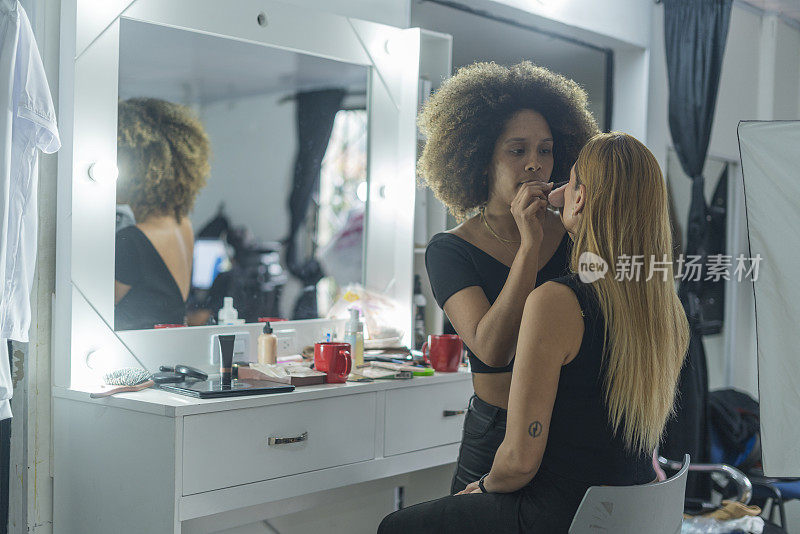 专业化妆师在她的美容院为她的客户服务
