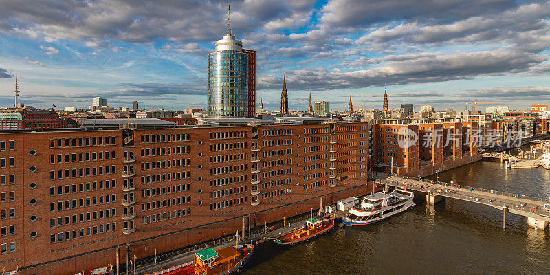 汉堡港城区的Speicherstadt。德国风景，德国旅行摄影。易北河与商业码头的照片。夕阳和天空，傍晚的好天气。港口的船只和建筑。