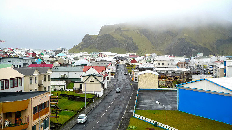 位于冰岛海岸外的宁静小镇Vestmannaeyjabær生活在两座火山的阴影下