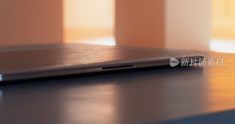 桌子上有一个小巧细长的笔记本电脑。