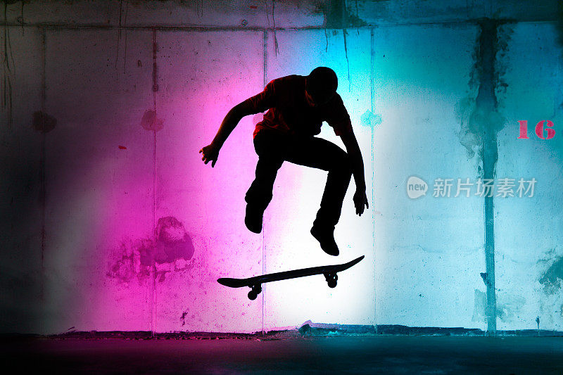青少年在夜晚跳跃，玩滑板黑色的剪影