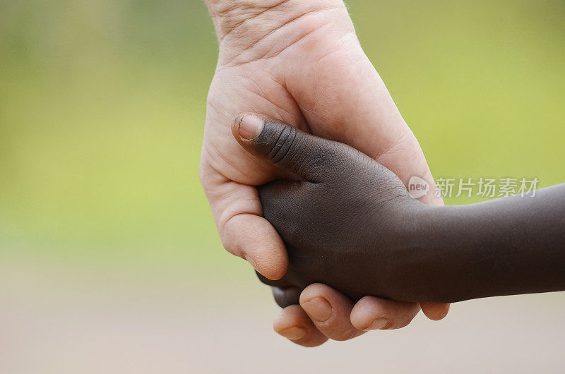 美丽的和平象征-白人妇女和黑人孩子手牵着手