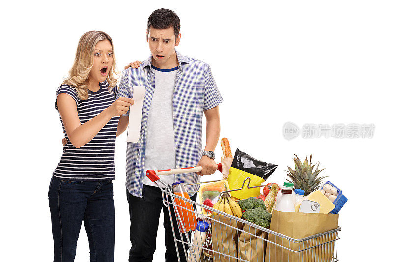 一对震惊的年轻夫妇看着购物账单