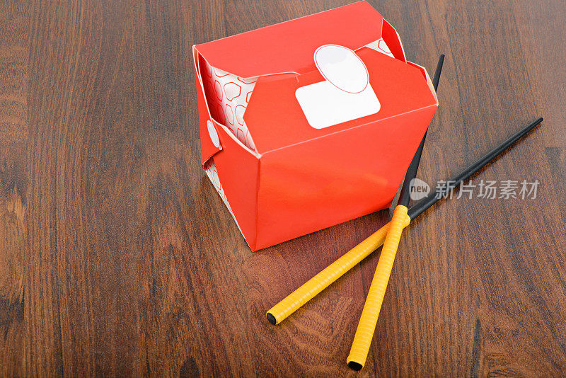 中国人用筷子拿走红色的食品盒