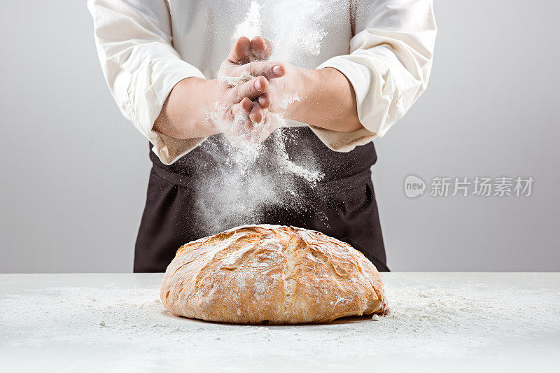 男子的手在面粉和乡村有机面包