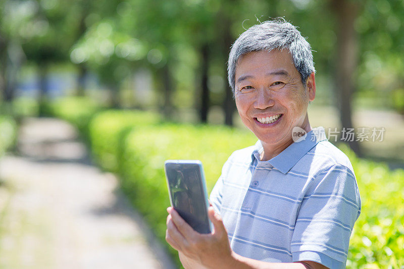 亚洲年长男子拿着智能手机