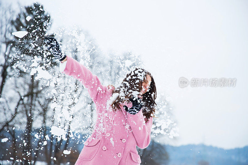 可爱的年轻女子被雪球砸中了