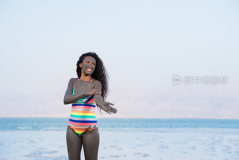 浑身沾满死海矿物泥的女人。