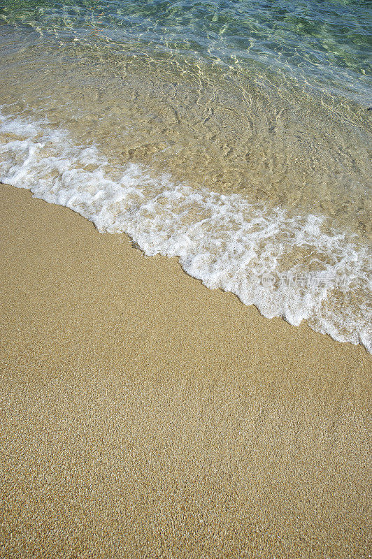 晶莹的波浪拍打着金色的沙滩