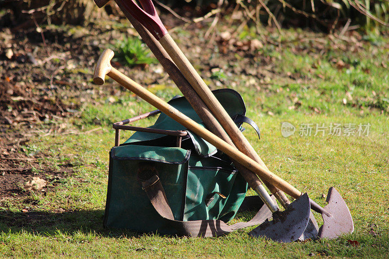 园丁的园艺工具在花园草坪上的形象，铁锹，袋子