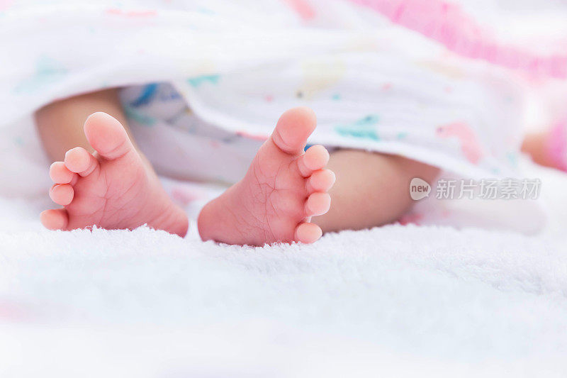 新生儿的小脚上裹着白色的毛巾
