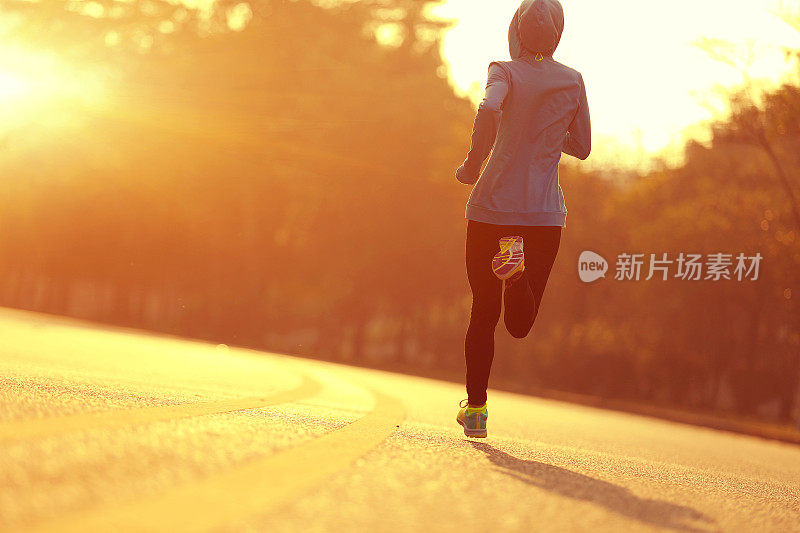 年轻的健身女运动员在日出路跑步