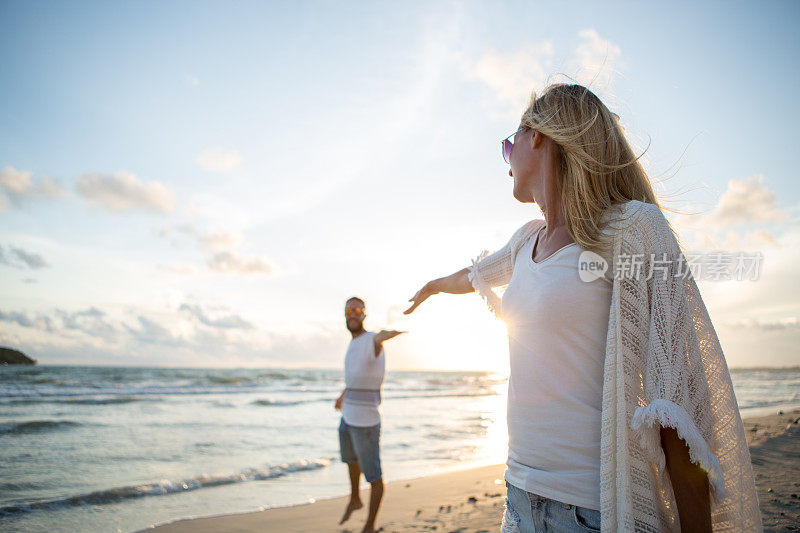 一对年轻夫妇在海滩上的团聚-日落