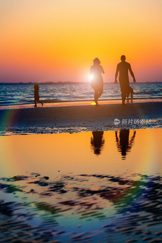 日落时分，一家人在海滩上散步