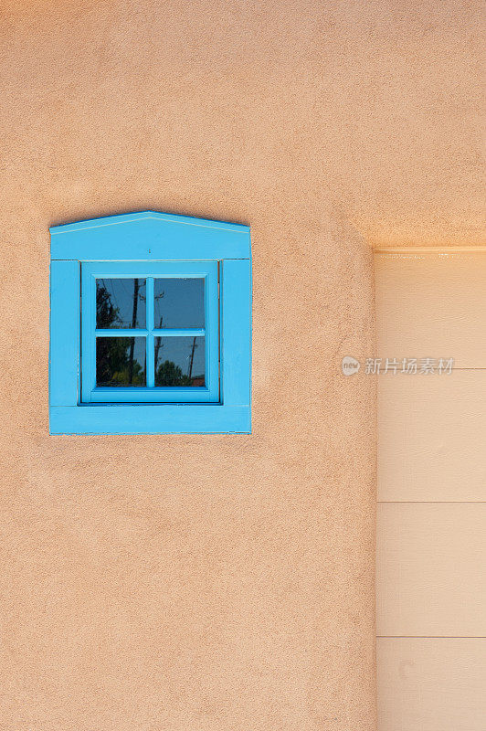 圣菲泥灰墙和蓝色窗户的土坯房子