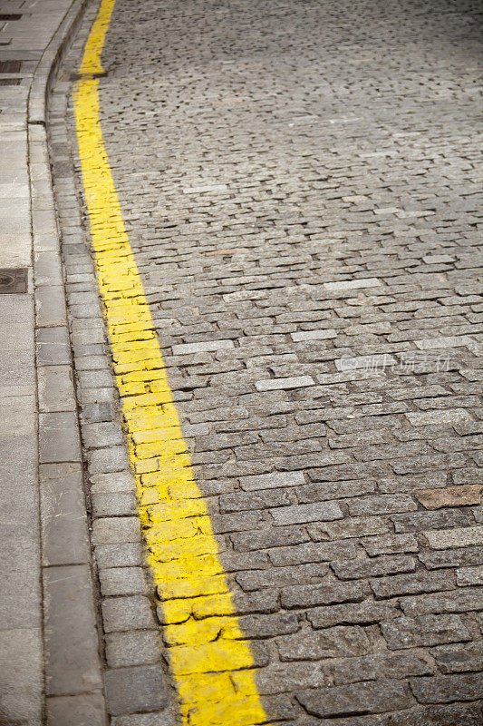 鹅卵石街道上的路缘和黄线。