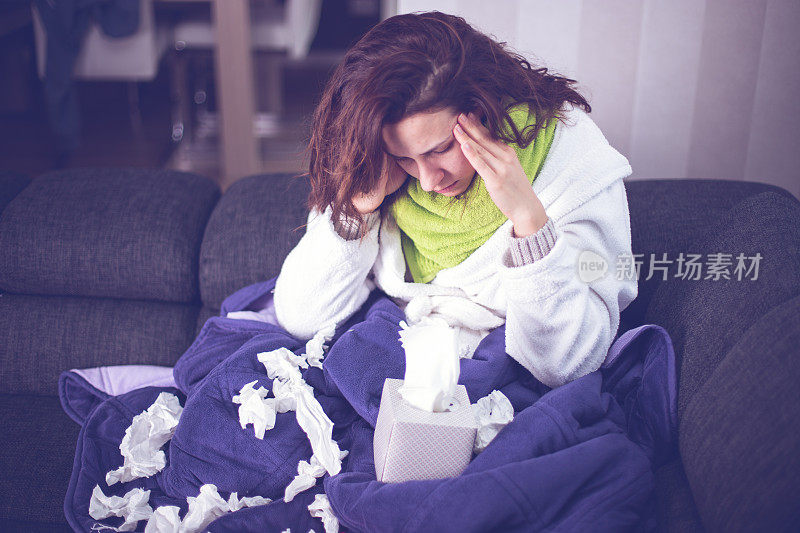 生病的女人患流感头痛在床上