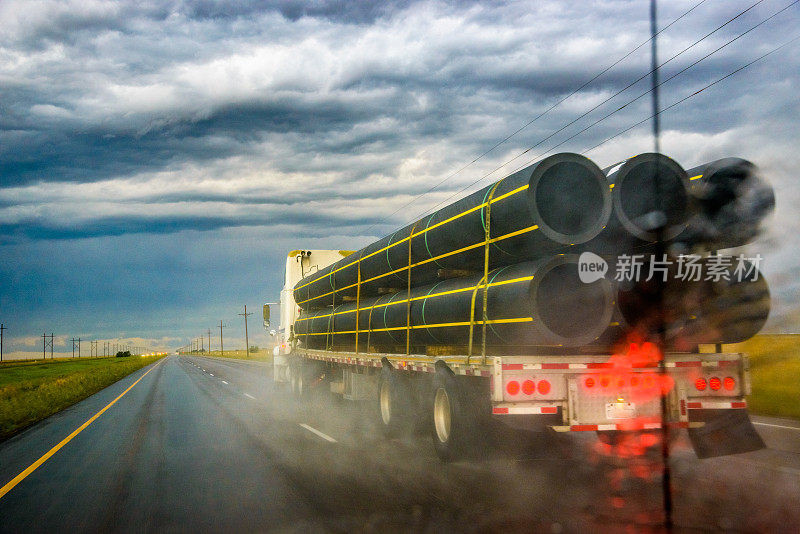 平板拖拉机挂车半卡车下不祥的黑暗暴风雨戏剧性的天空
