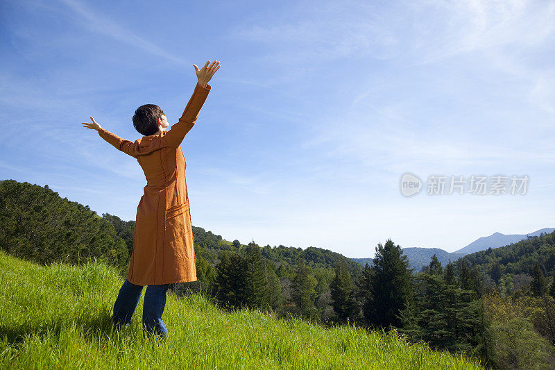 欣喜若狂的女人伸开双臂享受阳光