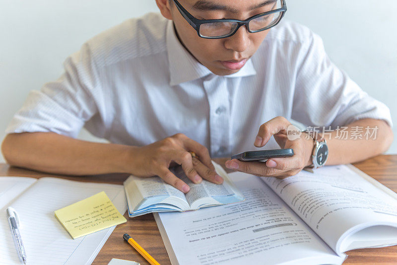 年轻的学生在学习和做作业时使用智能手机