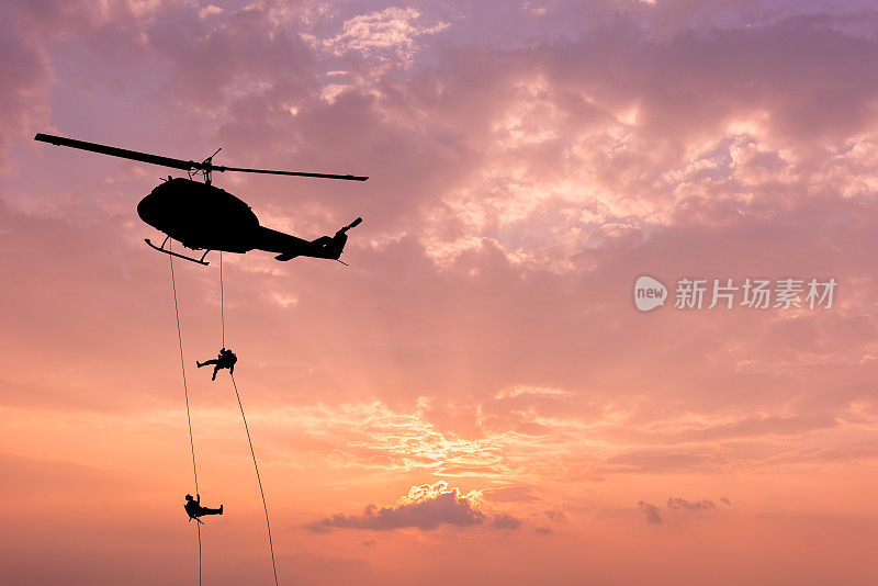 直升机的剪影，士兵救援行动直升机在日落天空的背景。