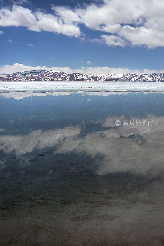 云雾倒映在圣湖Rakshastal无冰的水面上。
