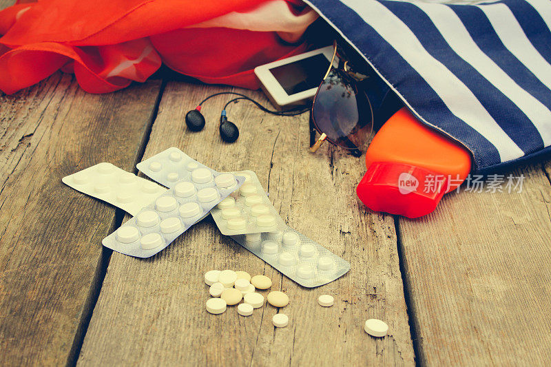夏季妇女的海滩配件为您的海上度假和药丸老木制背景。旅程中所需药物的概念。