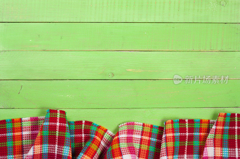 红色格子桌布，绿色木桌，为你的文本留出空间。俯视图