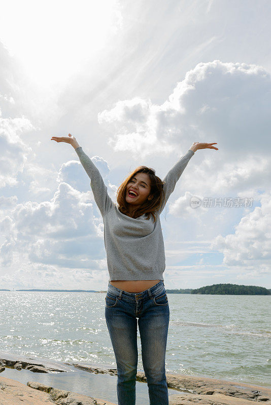 年轻美丽的亚洲女人对风景如画的湖在图尔库芬兰