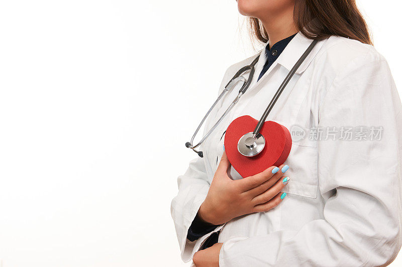 手持医用听诊器和红心的女医生