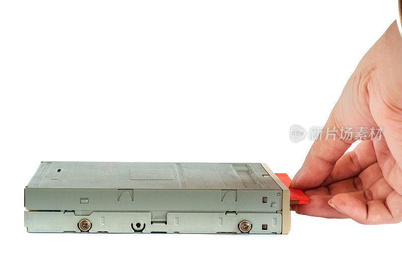 手把软盘放入白色背景的软盘驱动器中，老式技术和传统工业计算机设备