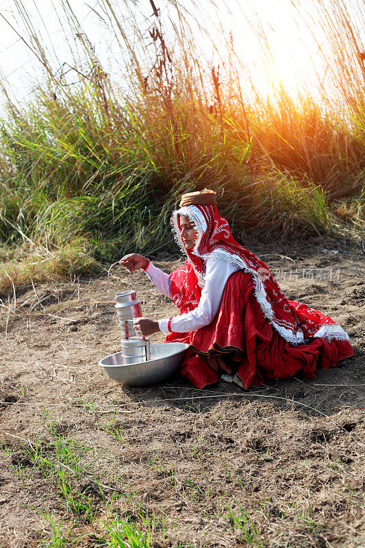 印度妇女坐在地里准备午餐