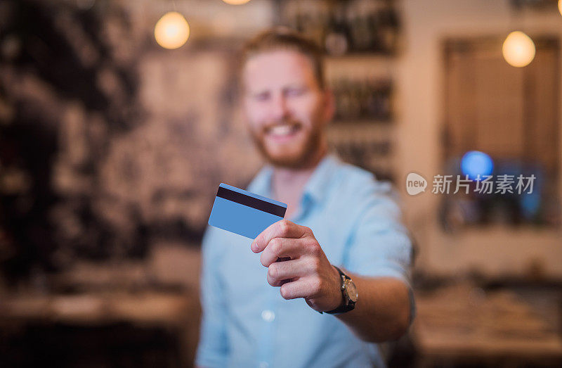 兴高采烈的年轻企业家拿着一张信用卡。