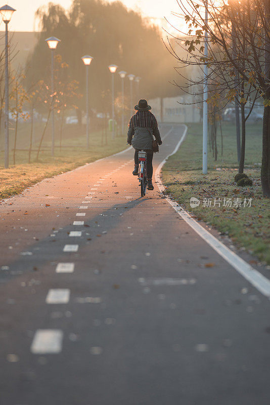 一个匿名的女人在一个秋日阳光明媚的日子里骑着一辆老式自行车