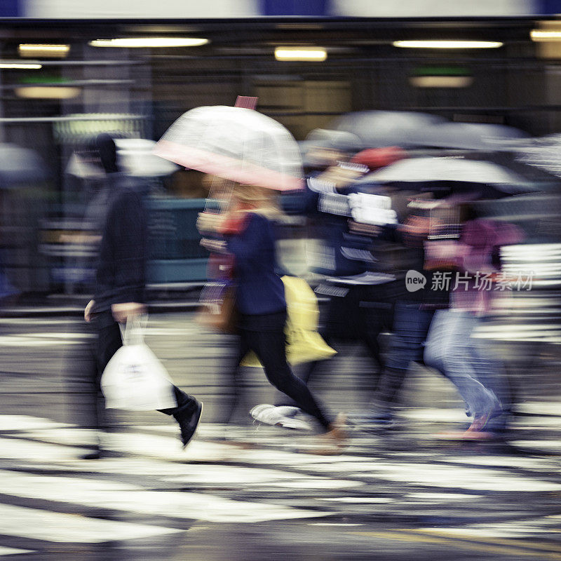 雨中的城市:行人在倾盆大雨中匆匆过斑马线