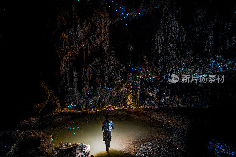 在新西兰的外普洞穴，站在萤火虫天空下的女孩