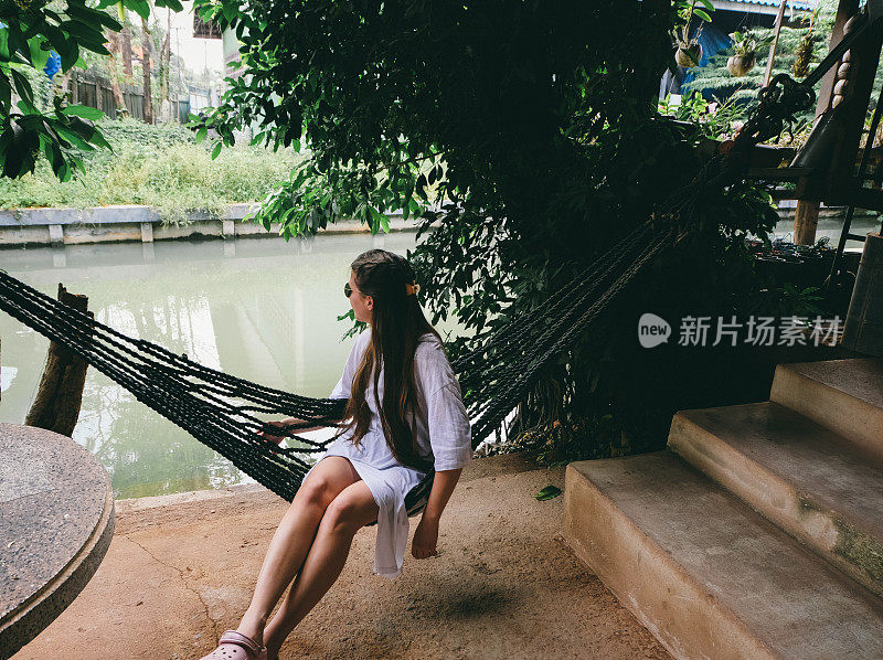 躺在吊床上看泰国河的女人