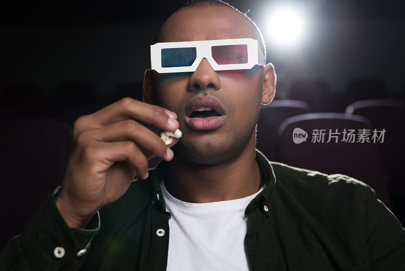 震惊的非裔美国人戴着3d眼镜在电影院看电影