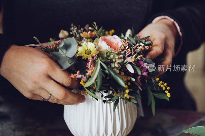 现代花匠工作与鲜花在车间-与手的细节