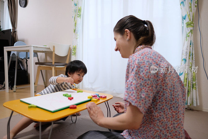 白种妇女教英文给亚洲幼童字母块