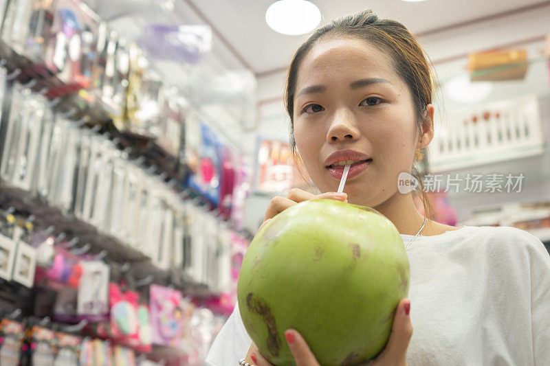 喝椰子水的亚洲女人