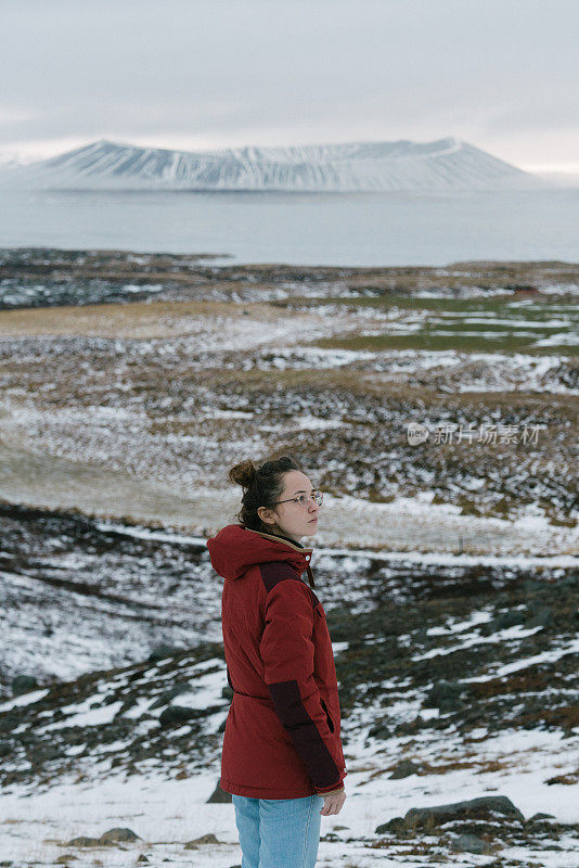 女人看风景的火山附近的Myvatn湖在冬天