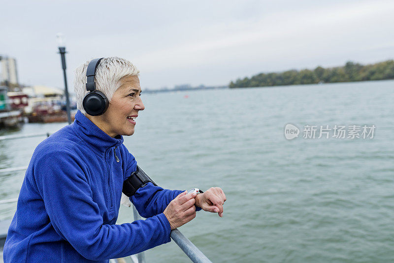 成熟的女人在户外运动后检查自己的身体状况